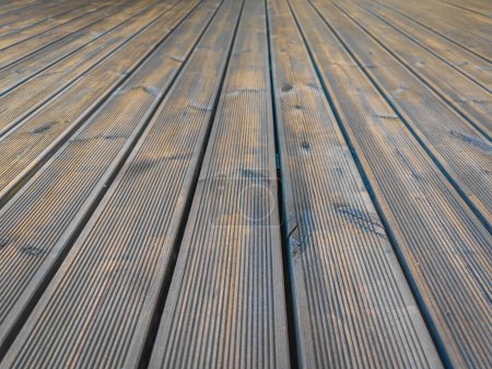 Terrasse en bois de pin cannelé fraîchement imprégnée d'huile brun foncé. Decking de vieilles planches de bois rénovées