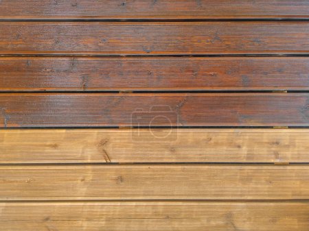 Terrasse en bois cannelé partiellement peinte et partiellement nettoyée imprégnée d'huile. Vue du dessus du pont des planches de bois