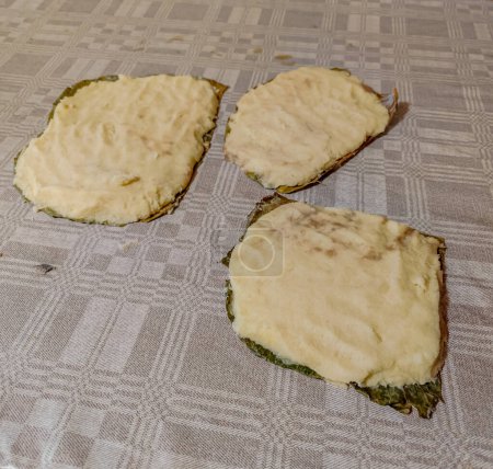Téléchargez les photos : Plat traditionnel lituanien Dzukiska banda gâteau aux pommes de terre ou pancake cuit sur une feuille de chou dans un four à bois - en image libre de droit