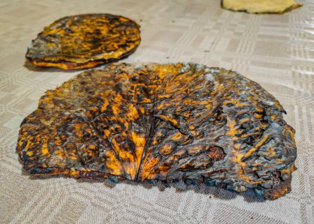Téléchargez les photos : Plat traditionnel lituanien Dzukiska banda gâteau aux pommes de terre ou pancake cuit sur une feuille de chou dans un four à bois - en image libre de droit