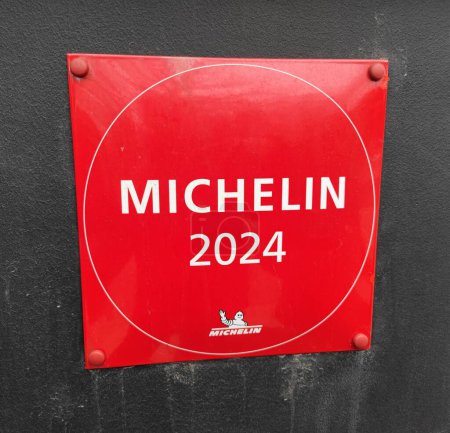 Foto de Riga, Letonia - 09 03 2024. Letrero de placa guía Michelin 2024 en un edificio con una pared exterior de restaurante buena y elegante. - Imagen libre de derechos