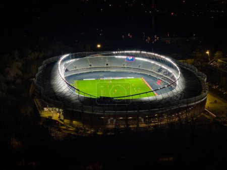 Kaunas Darius and Girenas stadium at night with lights on and football match going. Aerial view, drone photo