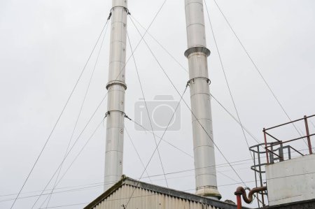 Photo for Flue chimney fixed to building exterior wall stainless steel from exhaust boiler plant room UK - Royalty Free Image