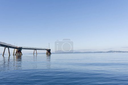 Photo for Old derelict wooden jetty pier in sea at Inverkip power station UK - Royalty Free Image