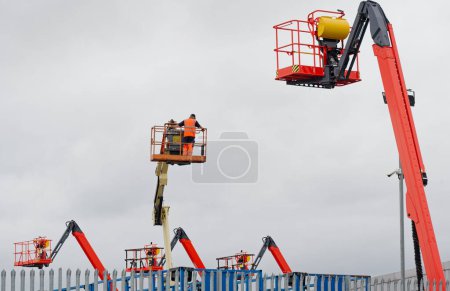 Foto de Equipo de plataforma de acceso alimentado alto en el cielo en el sitio de construcción Reino Unido - Imagen libre de derechos