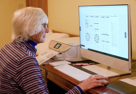 Téléchargez les photos : Senior ladys personnes âgées à l'aide d'un ordinateur pour jouer en ligne puzzles Royaume-Uni - en image libre de droit