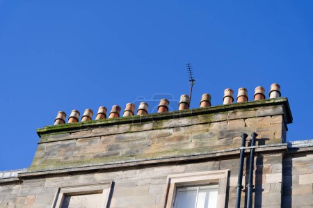 Téléchargez les photos : Pots de cheminée dans une rangée sur le toit de vieux bâtiment victorien Royaume-Uni - en image libre de droit