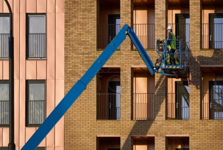 Foto de Elevador de tijera operado por trabajadores de la construcción para un acceso seguro a la altura - Imagen libre de derechos