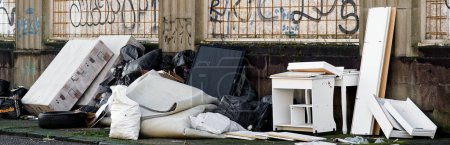 Volquete de basura y muebles viejos en la calle Reino Unido