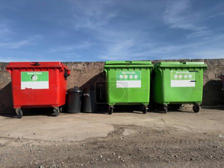 Cubos de ruedas en fila segregados para reciclar basura Reino Unido