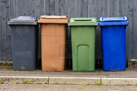 Wheelie bins in row segregated for recycling rubbish UK
