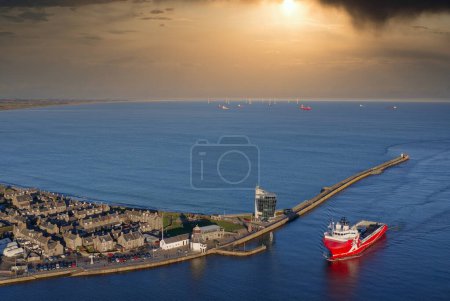 Ship arriving at Aberdeen harbour after passing Girdle Ness Lighthouse UK