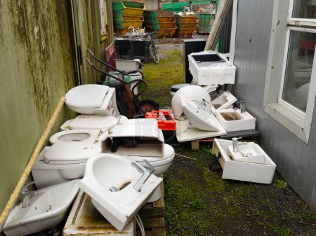 Old basins and toilet pans at scrap compound UK