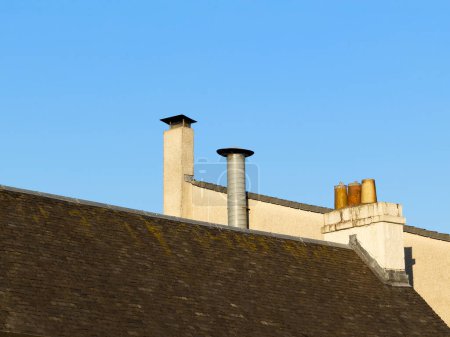 Photo for Chimney pots in a row on old building roof UK - Royalty Free Image