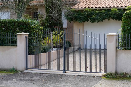 Téléchargez les photos : Grille grise de portail privé classique maison individuelle dans la rue de banlieue - en image libre de droit