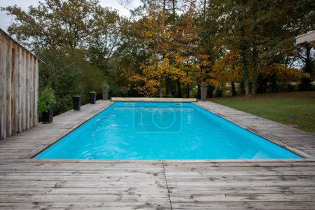 Téléchargez les photos : Maison piscine bleue avec terrasse en bois maison de jardin - en image libre de droit