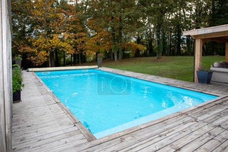 Téléchargez les photos : Coin en bois de la piscine avec eau bleue - en image libre de droit
