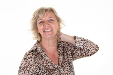 Foto de Smiling senior 60 woman with blond hair elderly lady hand in the neck on white background - Imagen libre de derechos