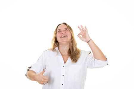 Téléchargez les photos : Plus size pretty woman looking happy ok finger hand sign and thumbs up fingers smiling  in fun victory concept - en image libre de droit