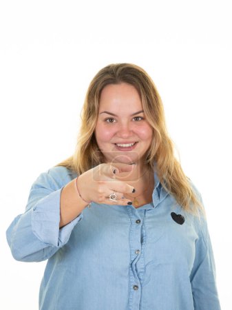 Téléchargez les photos : Plus size girl in blue shirt fat woman portrait pointing hand fingers on white background - en image libre de droit