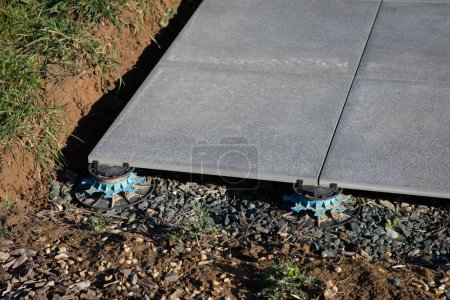 Téléchargez les photos : Exterior pavement tiles installation on the house terrace with adjustable plots - en image libre de droit