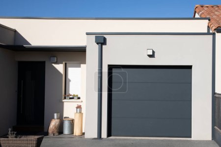 modern grey house with gray garage door portal of suburb new house
