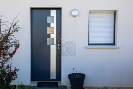 Téléchargez les photos : Nouvelle porte grise moderne avec entrée en aluminium à la façade de la maison - en image libre de droit