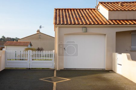 Foto de Moderna fachada privada entrada casa suburbio con garaje puerta blanca puerta superior pvc coche entrada - Imagen libre de derechos