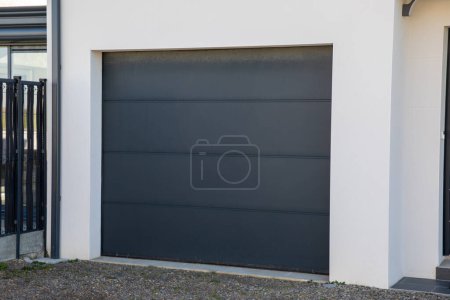 modern grey house with gray garage door sectional portal of suburb new house