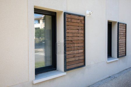 Photo for Home shutter wood windows with modern wooden brown sliding shutters in house beige new facade apartment city building - Royalty Free Image