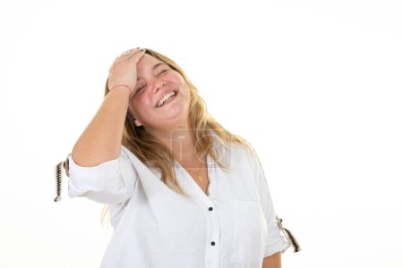 Téléchargez les photos : Rire amusant blonde oversize femme main doigt sur cheveux souriant heureux sur fond blanc - en image libre de droit
