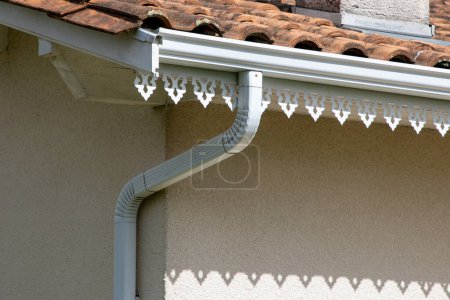 Téléchargez les photos : Système de garde de caniveau blanc bord goutte à goutte avec décoration design sous le toit sur le quartier moderne de la maison - en image libre de droit