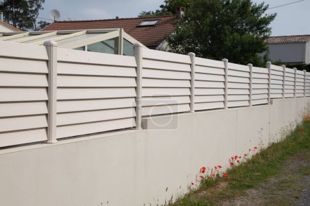 Téléchargez les photos : Mur rue barrière moderne blanche et clôture pvc plastique autour de la maison protéger vue jardin maison - en image libre de droit