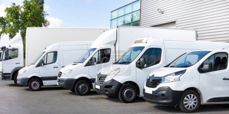 Foto de Varios coches furgonetas camiones estacionados en el estacionamiento para la entrega de envío Fuera de Logística Distribuciones Almacén - Imagen libre de derechos