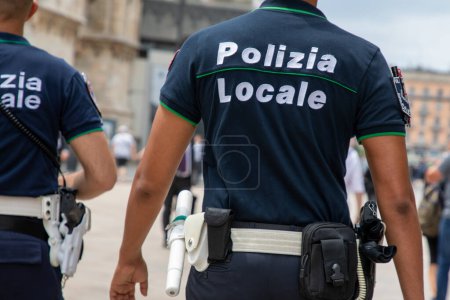Foto de Milán, Italia - 08 17 2023: polizia locale policeman shirt with text sign police Italian local police patrol in city street - Imagen libre de derechos
