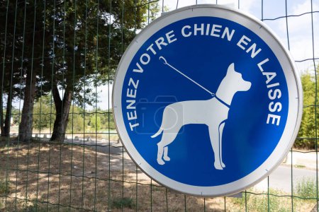 Photo for Panel signage keep your dog on a leash sign french text means tenez votre chien en laisse - Royalty Free Image