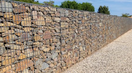 Foto de Fondo pared gaviones cerca acero metal rallado piedra pared cesta albañil hecho fachada urbana piedras - Imagen libre de derechos