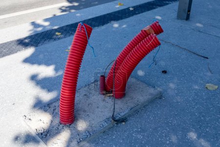 Téléchargez les photos : Tuyau rouge ondulé avec câble électrique sortant du sol - en image libre de droit