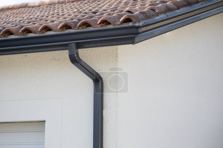 Foto de Canalón gris nuevo sistema de guardia techo goteo borde en la casa moderna barrio gris - Imagen libre de derechos