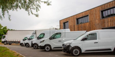 biały van dostawy grupy niemarkowe białe furgonetki o różnej wielkości gotowy do dostaw z tekstami i logo w parku magazynowym
