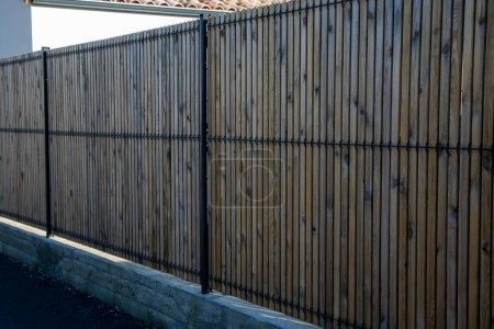 Photo for Palisade wooden steel modern panel fence for home protect garden house - Royalty Free Image