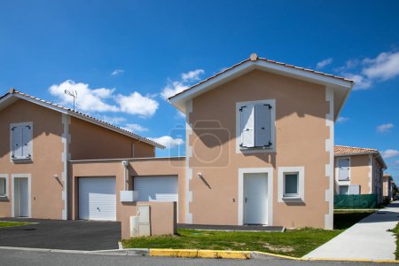 Photo for Recent new semi-detached houses on one floor in a subdivision of terraced houses by the garage facade of house just finished built - Royalty Free Image