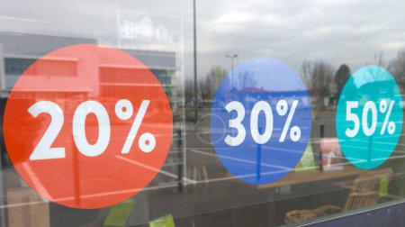 Téléchargez les photos : Ventes dans les vitrines d'autocollants de magasin 20 30 50 pour cent hors promotion dans le magasin de vêtements - en image libre de droit