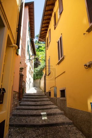 Foto de Italiano pintoresca calle fachada amarilla edificio de la casa en hermoso lago Bellagio Como en el norte de Italia - Imagen libre de derechos