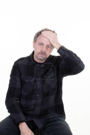 man dsappointed with hand on forehead suffers from headache on white background
