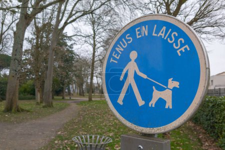 Photo for Please keep your dog on a lead information french text sign means  france chien tenus en laisse to protect wildlife and other people walking in the area from a dog attack - Royalty Free Image