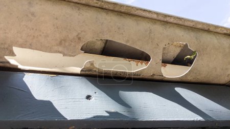 Canaletas dañadas después de una tormenta de granizo con agujeros y el impacto de granizo grande que espera canalón Reparación del techo Canalón