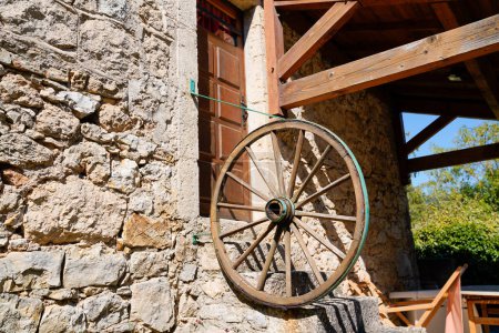 ferme typique ancien bâtiment avec roue de vieille charrette à cheval en façade dans lozere aveyron