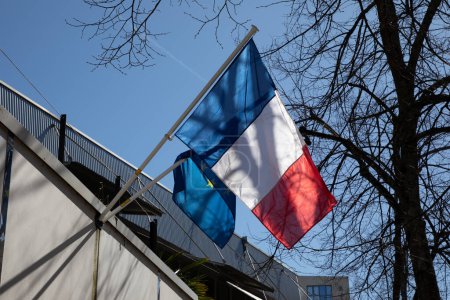 Französische Flagge auf dem Hausmast am blauen Himmel