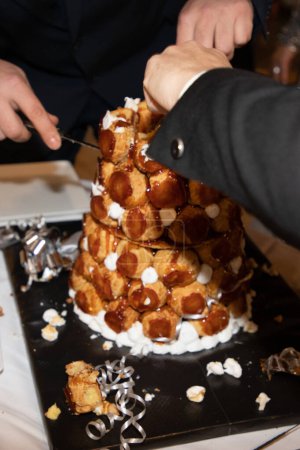 Croquembouche avec caramel et aiguilles de serveur pour gâteau de mariage sur la table